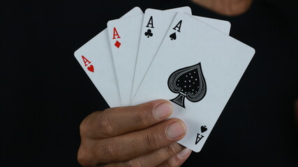 hand holding four aces. Gambling addiction.