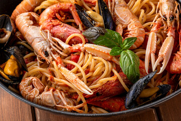 Spaghetti allo scoglio, ricetta tipica di pasta italiana condita con salsa ai frutti di mare, cibo italiano  - obrazy, fototapety, plakaty