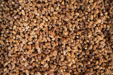 Close-up of a yellow mulberry on a stall at a bazaar.