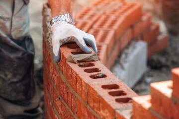 hand of Bricklayer working leveling on curved wall