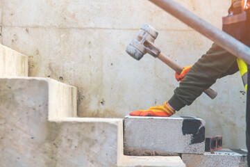 Builder making concrete steps for pedestrian walkway footpath in city. Adjusting precast concrete...