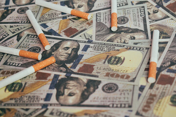 Smoking concept cigarettes on dollar background Cigarettes scattered on dollars.
