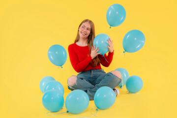 happy woman with balloons on yellow background