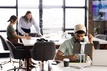 An Asian woman and boy work with colleagues; a Caucasian girl walks by, copy space