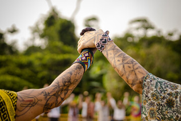 Sao Paulo, SP, Brazil - April 20 2023: Women holding hands in the air, painted arms and colorful...