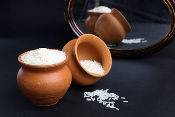 rice grains in the clay pot. traditional mud pot vessel to preserve or cook rice. Also have refclation from mirror.
