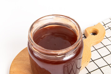 Jam in a glass jar on wooden board. Soft focus. Apple jam