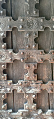 Closeup of a wooden door with metal studs on an ancient building facade