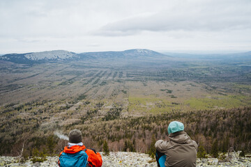 Two people enjoy the view of the natural landscape from a mountain top