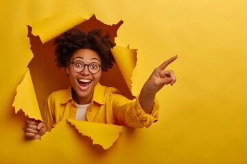 black Woman hand arm pointing on copyspace isolated through torn yellow wall orange background studio. Copy space advertisement place for text or image promotional, mock up - Powered by Adobe