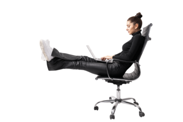 A woman sitting in a black office chair, legs up while using a laptop, on a white background, depicts a relaxed work concept