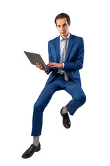 A man in a blue suit sitting mid-air while using a laptop, on a white background, concept of...