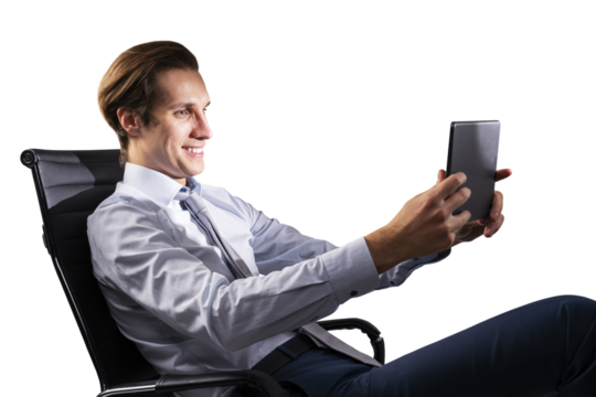 A smiling businessman in a shirt and tie sitting in an office chair and using a tablet against a white background, concept of technology at work