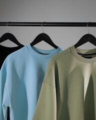 three T-shirts hanging on hangers