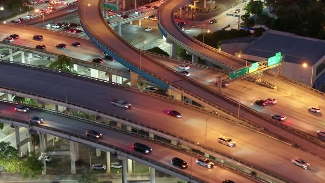 Aerial reveal shot of cars driving on Downtown I95 Riverside multilane highway at night, transport infrastructure in Miami. Drone flight over rush hour traffic on the highway in Miami 