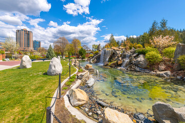 View of the downtown skyline and Front Street from the lakeside McEuen Park and the city's large water feature, in Coeur d'Alene, Idaho USA.