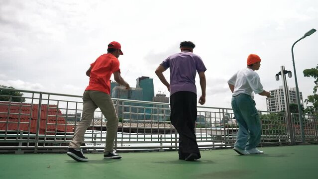 Group of skilled break dancer perform hip hop foot step together at rooftop with city or skyscraper view. Handsome hipster team moving to funky music at public place. Outdoor sport 2024. Sprightly.