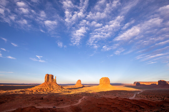 Famous view from Monument Valley lookout point at sunset with illuminated buttes on a sunny day with blue sky in Arizona, USA