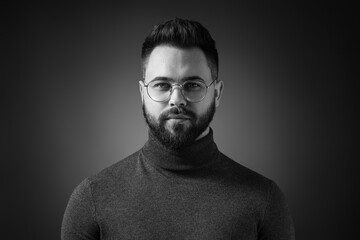 Portrait of handsome bearded man on dark background. Black and white effect