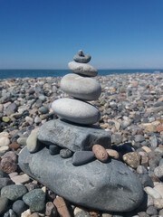 Stones on the beach. Pyramid of stones on the sea beach.