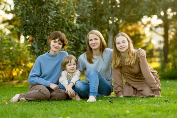 Family of four having fun outdoors. Two teenage girls with a toddler boy on autumn day. Children...