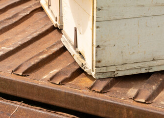 A wooden box is sitting on a metal surface. The box is old and has a rustic appearance