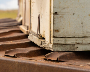 A wooden box with a hole in it is sitting on a train track. The box is old and has a rustic...