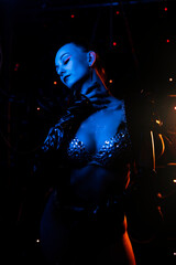 Beautiful go-go dancer posing in a nightclub. atmospheric blue light. Party concept, nightclub