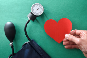 Blood pressure health concept with hand with heart and tensiometer