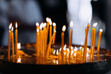 Burning church candles in a gilded candlestick in a temple in the dark. candles are burning in the...