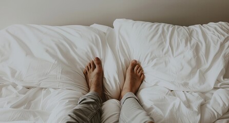 Photo of two sets of feet, one set is the man's and the other is the woman's, laying on white bed sheets. The feet are barefoot.