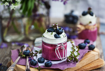 Blueberry Panna Cotta decorated with cream and fresh berries