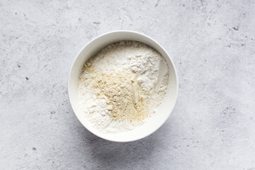 All purpose flour and vital wheat gluten in a ceramic bowl, process of making bread flour