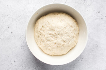 Bread dough that has doubled in size, dough that has risen, proofed dough in a white bowl