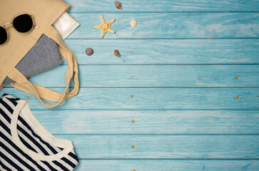 Beach outfit on a blue wooden background. Top view, copy space