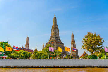 View from the river to the embankment and the temple Wat Arun in Bangkok temple, Thailand