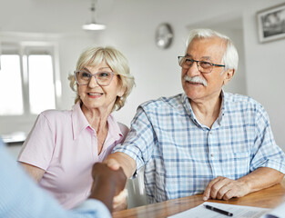 senior couple investment finance agent agreement contract handshake document teamwork greeting cooperation hand trust shaking partner signature business meeting businessman