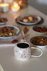 Cup of tea or coffee, cookies, macaroons, chocolate, various nuts and cocoa powder on white background. Selective focus.