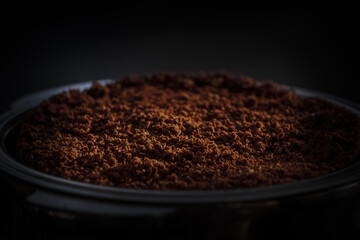 Freshly ground dark roast coffee in an espresso portafilter.