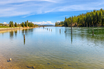 Riverbank view of the Spokane River as it runs through a rural forested area on it's way to the...