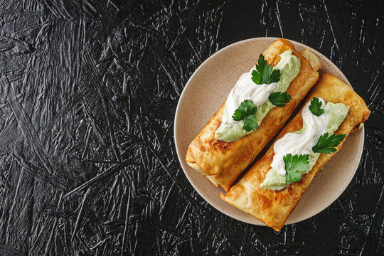 set of delicious fresh colorful deep-fried chimichanga on a dark background