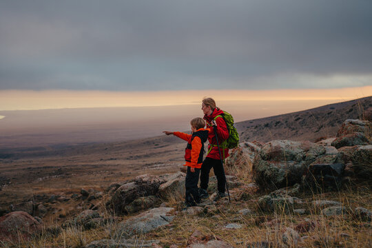 Woman tourist with son standing on the mountain and looking out into the distance