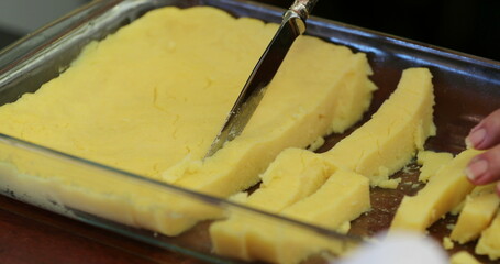 Cutting traditional Brazilian polenta ready for cooking