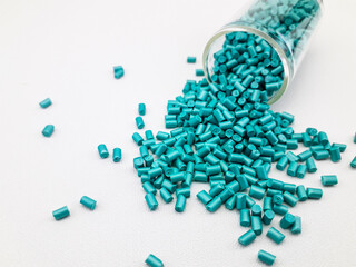 pearl turquoise masterbatch granules with a glass tube on a white background, this polymer is a...