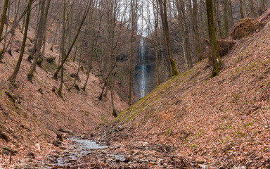 High waterfall in the spring forest.