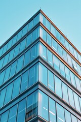 Obraz premium Modern glass building with a clock on top, suitable for business concepts
