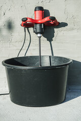 handheld electric concrete mixer on construction site