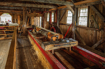 A log on a carriage being cut with a head saw in an old water-powered sawmill.