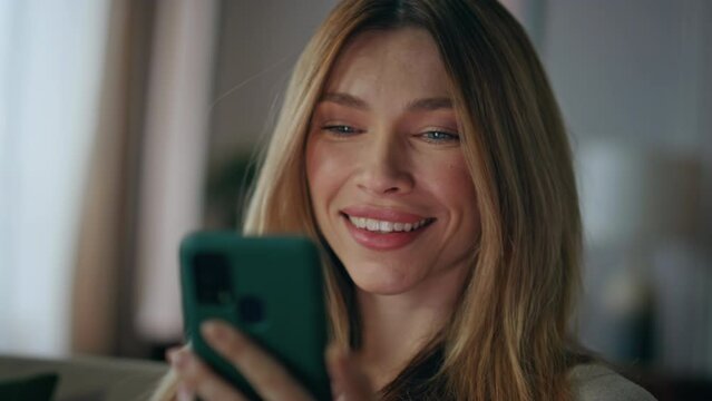 Happy businesswoman receiving cellphone notification salary at apartment closeup