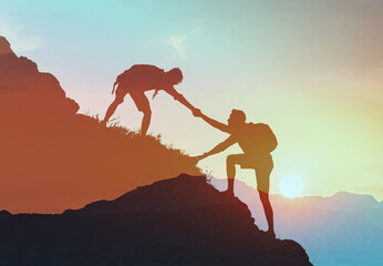 Team work, life goals and self improvement concept. Man helping his friend climbing partner up a...